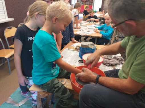 Chłopiec wykonuje naczynie z gliny