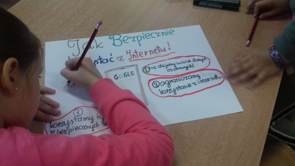 dziewczynka rysuje plakat o bezpieczeństwie w Internecie