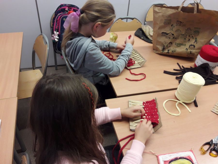 Uczennice z klas trzecich wyplatają dywaniki z bawełnianych sznurów