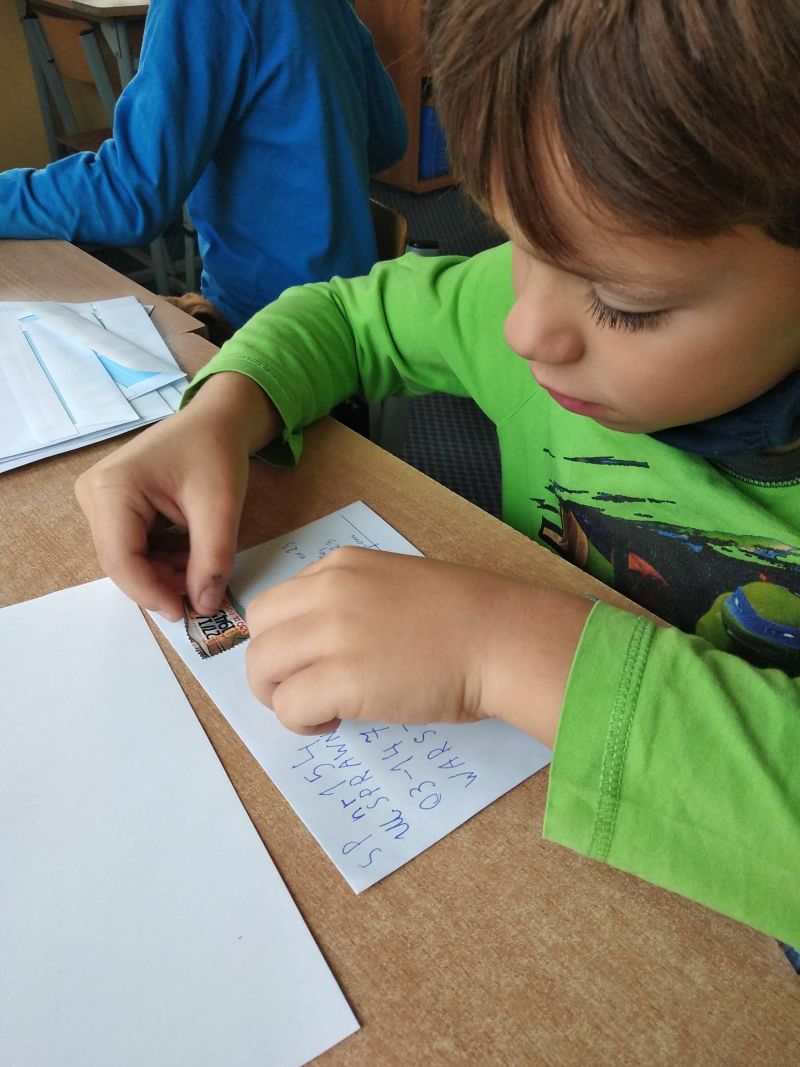 chłopiec nakleja znaczek