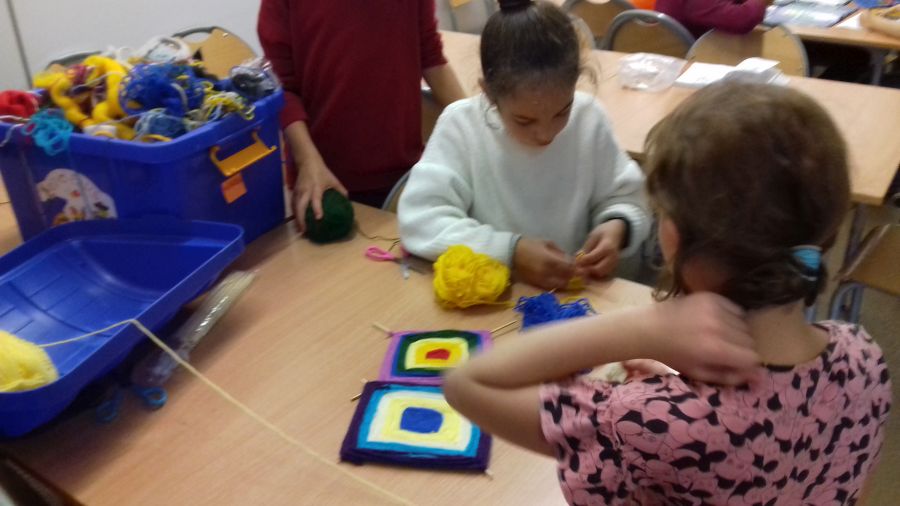 Dziewczynki robią dywaniki z włóczki i patyczków