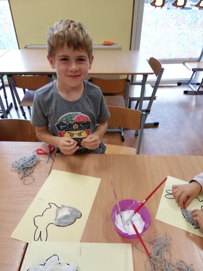 chłopiec wykonujący pracę plastyczną