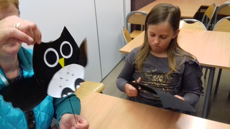 Pani prezentuje zabawkę ruchomą - sowę wykonaną z papieru kolorowego, dziewczynka wycina sowę z papieru 
