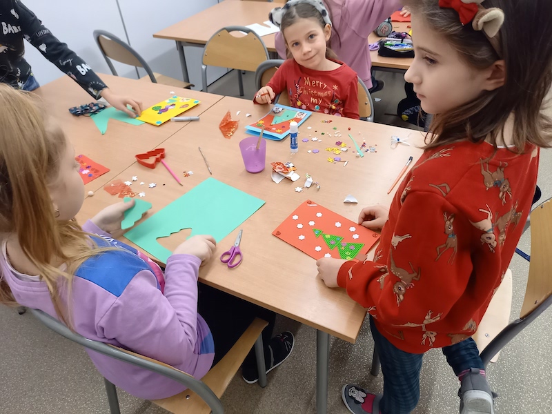 dzieci wykonują kartki świąteczne z papieru kolorowego 