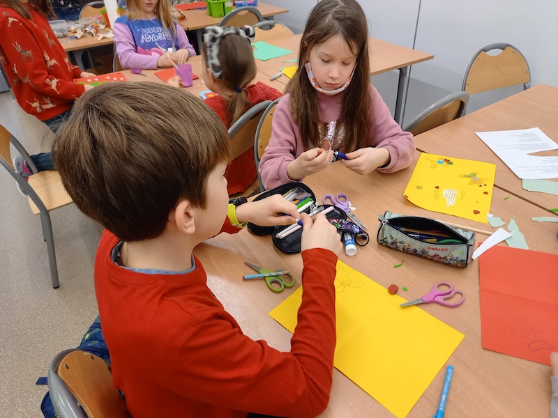 dzieci wykonują kartki świąteczne z papieru kolorowego 