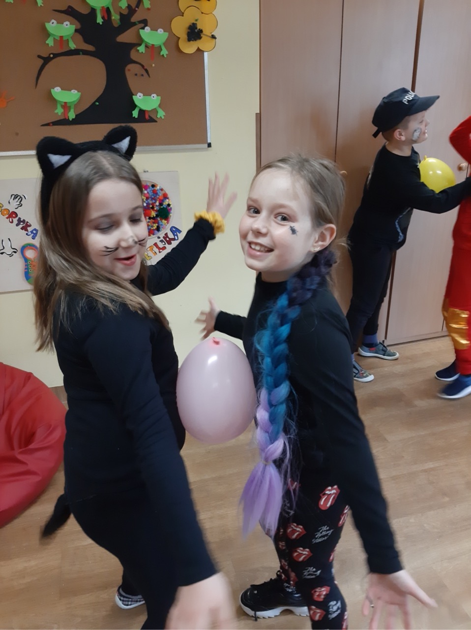 Zdjęcie przedstawia uczniów przechodzących pod liną podczas zabawy limbo 