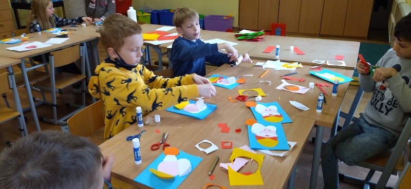 uczniowie wycinają i naklejają