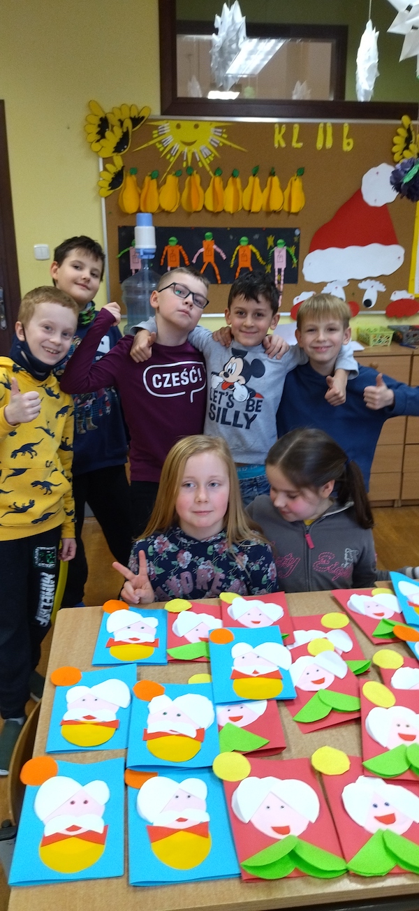 Zdjęcie przedstawia grupę uczestników, którzy prezentują gotowe prace