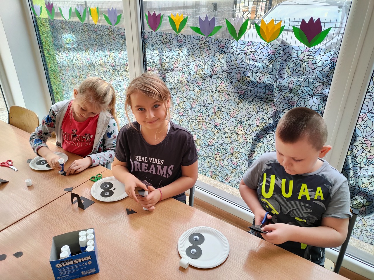 zdjęcie przedstawia dzieci wykonujące pandę