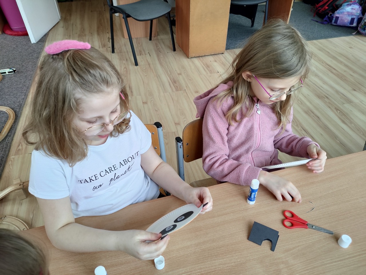 djęcie przedstawia dziewczynki wykonujące pracę plastyczną