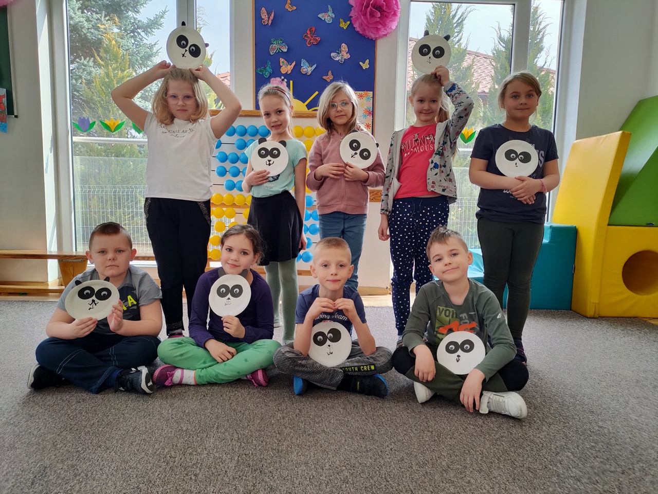 zdjęcie przedstawia dzieci prezentujące wykonane przez siebie prace