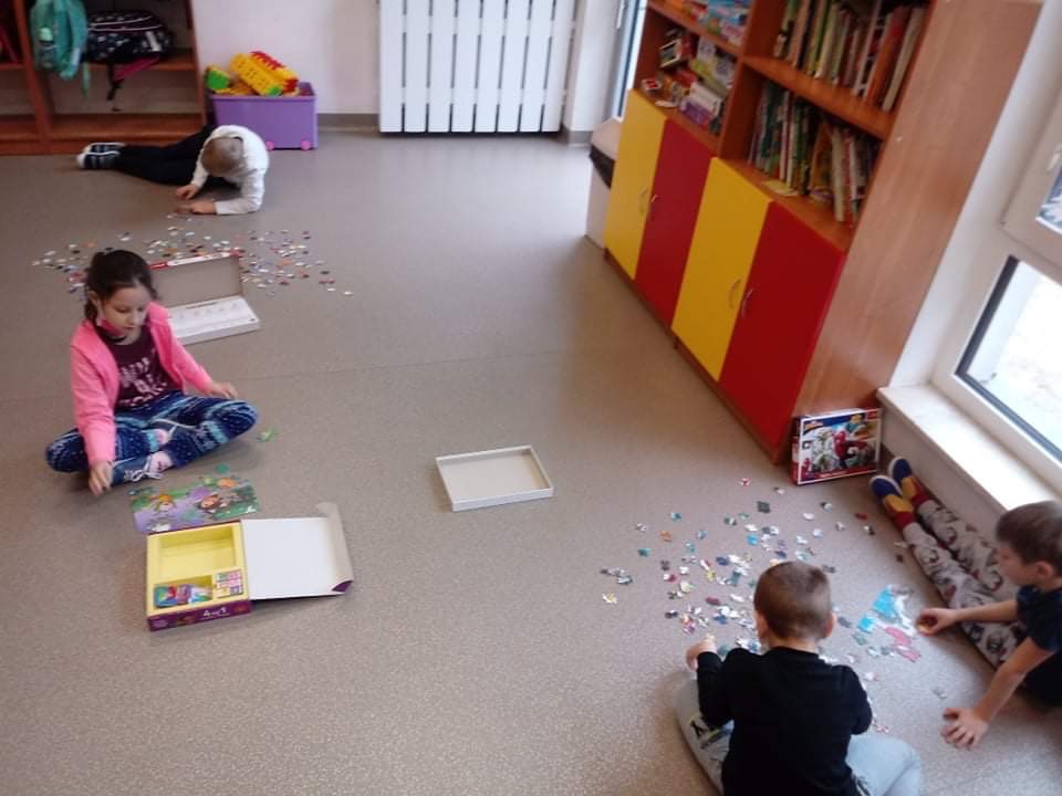 dzieci w grupach układają puzzle  
