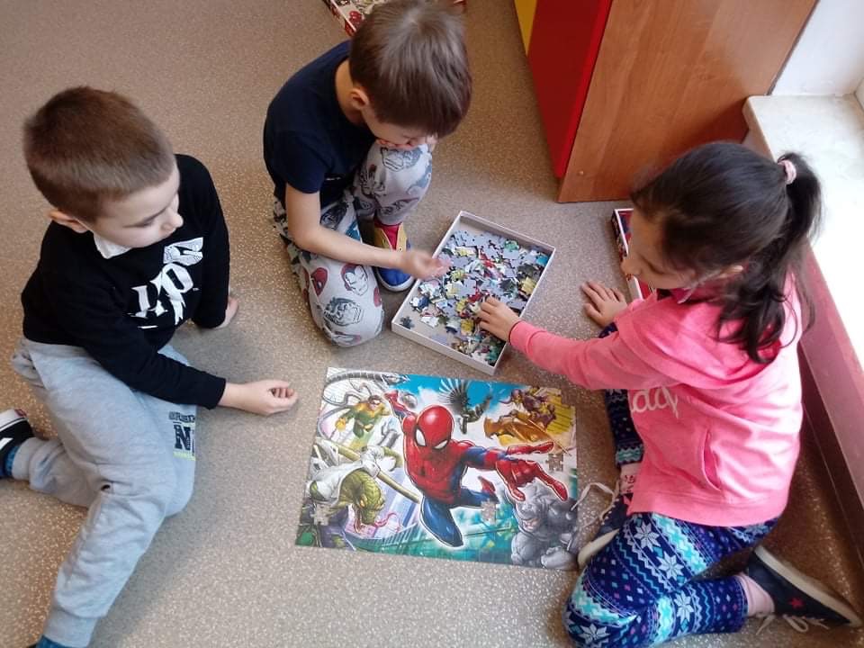 dzieci układają puzzle z wizerunkiem Spidermana 