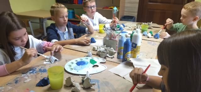Zdjęcie przedstawia uczniów malujących wytłaczanki.