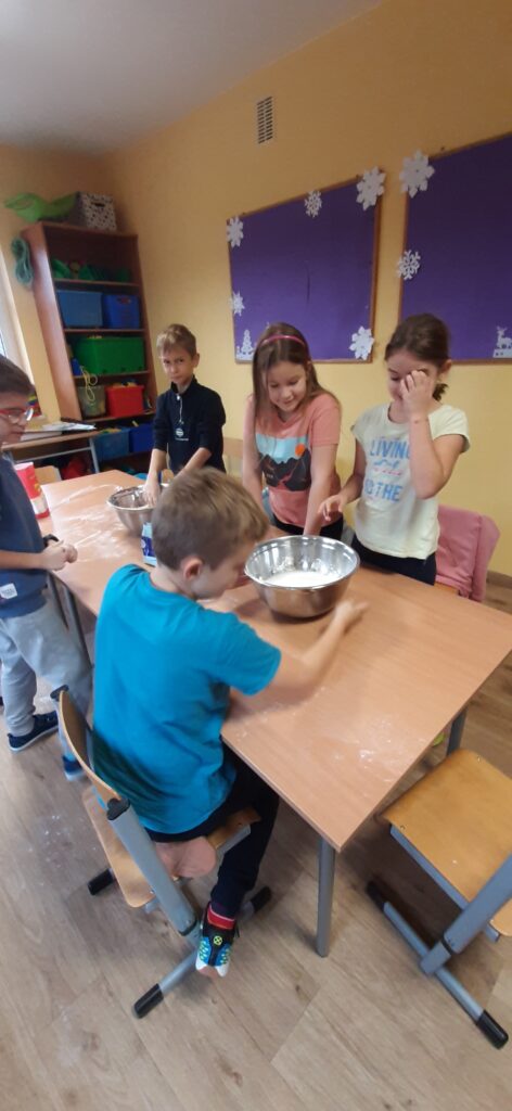 zdjęcie przedstawia uczniów wyrabiających masę solną 