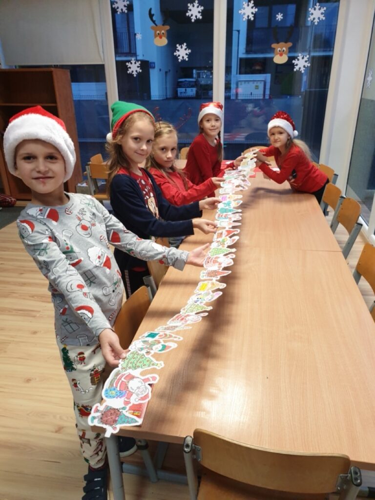 dzieci prezentujące wykonany przez siebie łańcuch św. Mikołaja