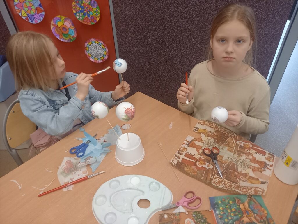 dziewczynki ozdabiają bombki techniką decoupage