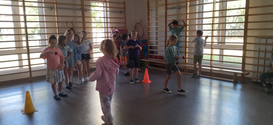 dzieci uczestniczą w konkurencji zręcznościowej z jabłkami kto szybciej doniesie jabłko na łyżce do celu