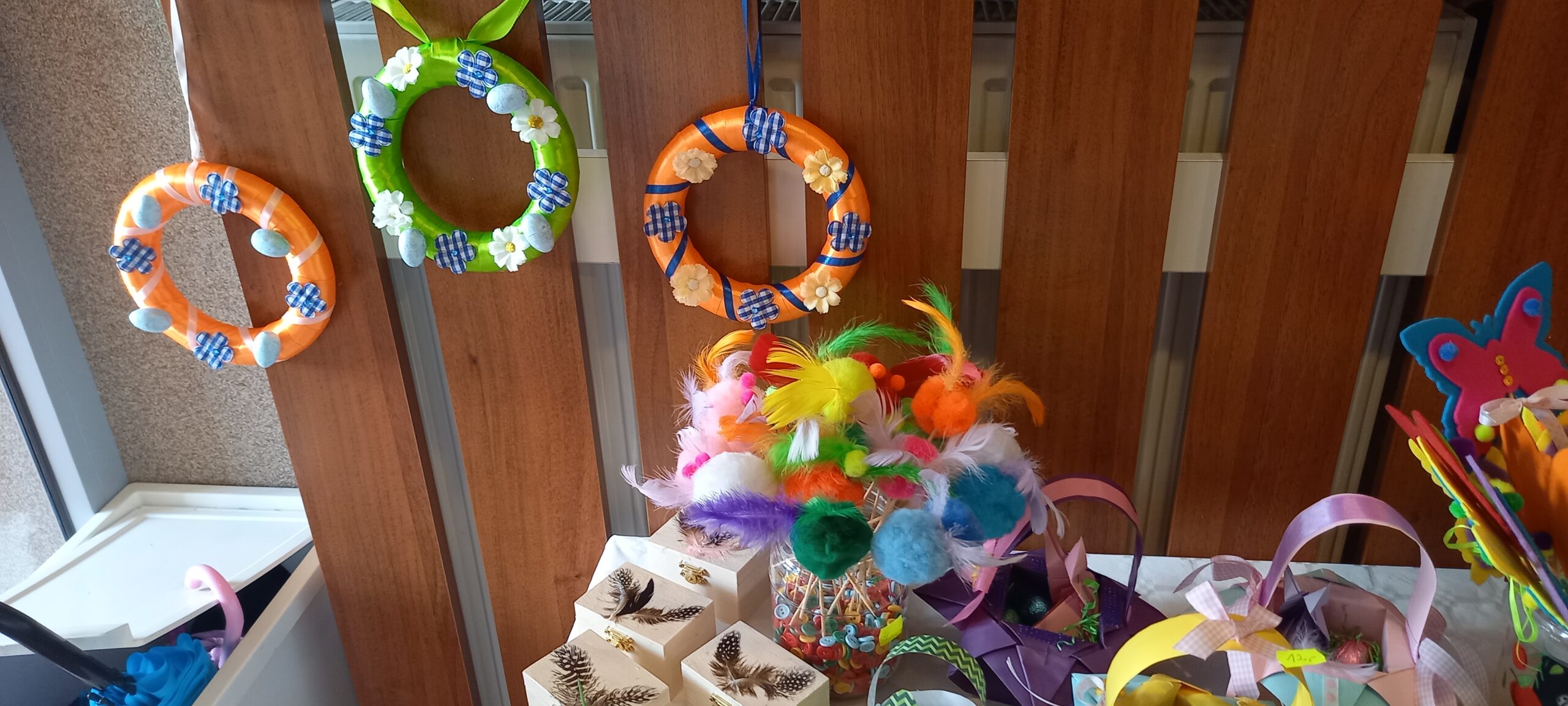 ozdoby wielkanocne na kiermaszu wielkanocnym: wianki, ozdoby do doniczki z piórkiem, szkatułki