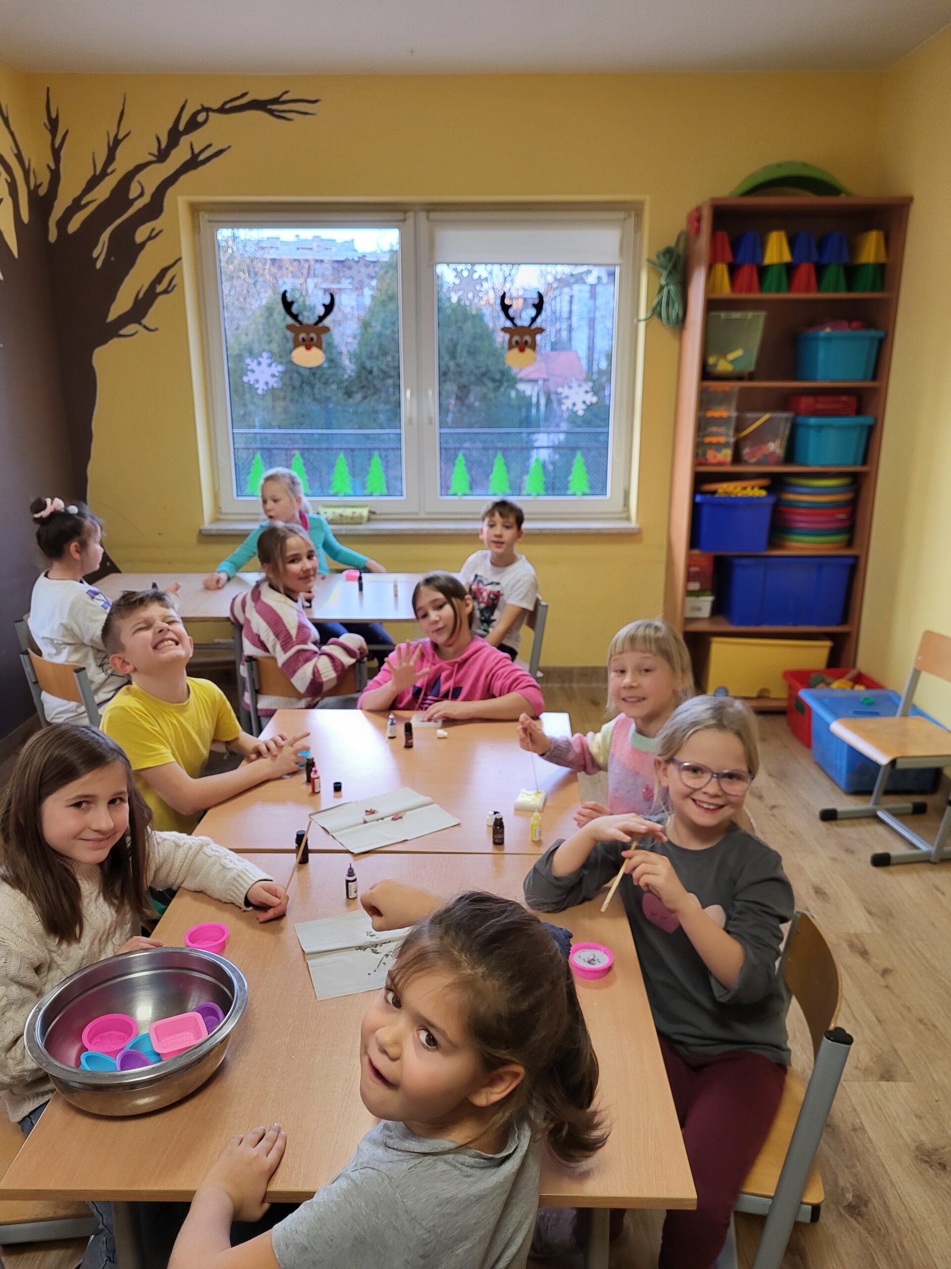  uczniowie siedzący przy stoliku z wybranymi zapachami i barwnikami