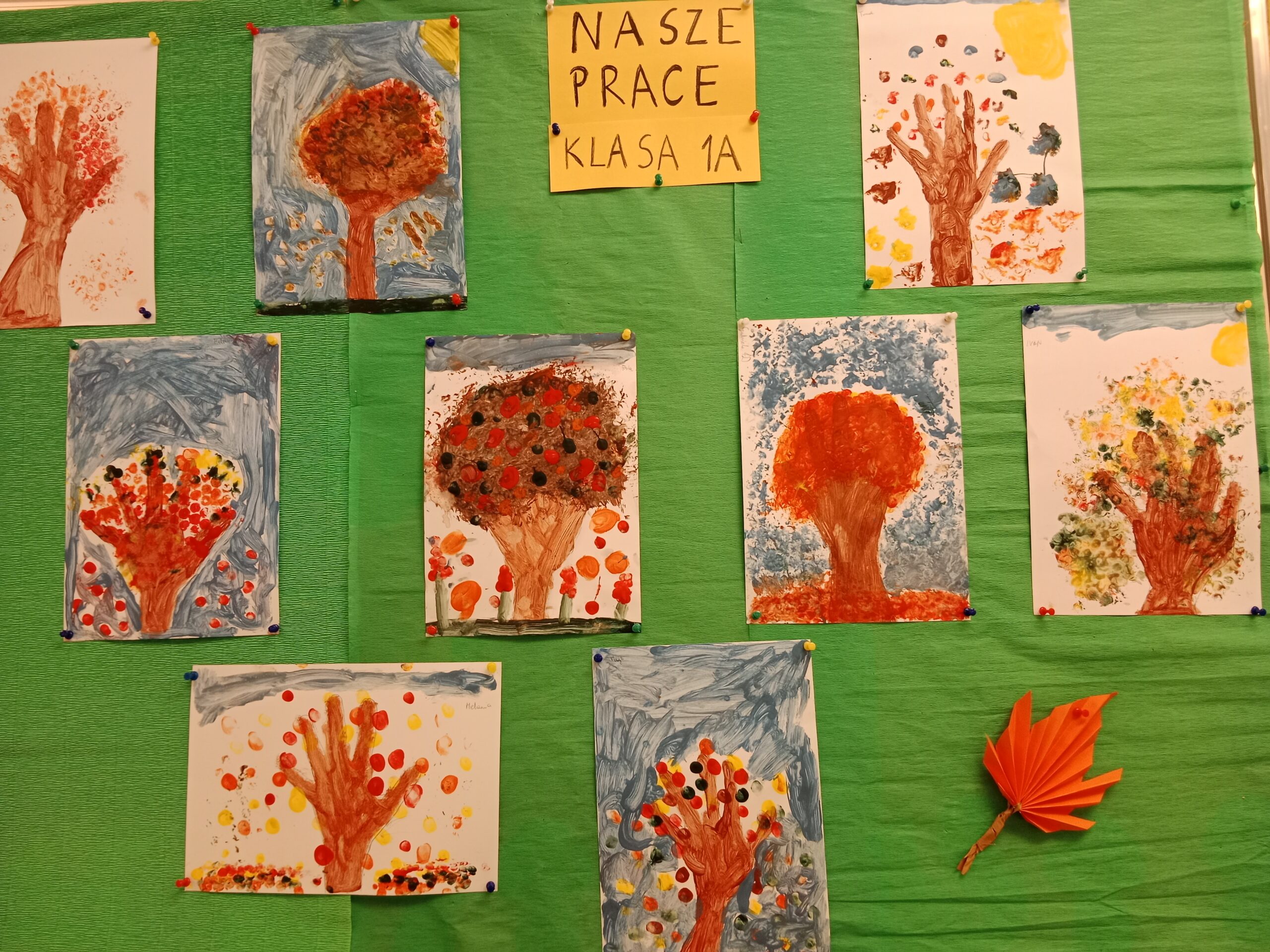 Zdjęcie przedstawia tablice na której znajdują się jesienne drzewka wykonane przez dzieci z klasy 1a.