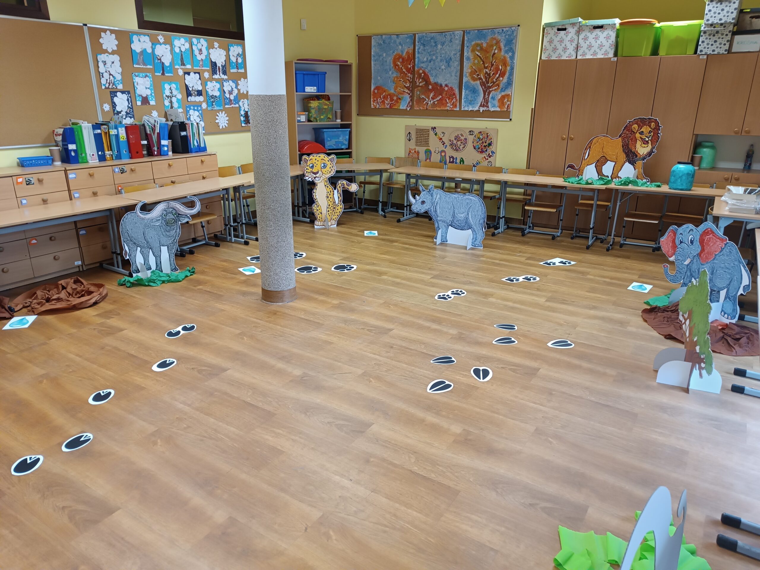 Na zdjęciu widać salę przygotowana do zajęć, są w niej naklejone ślady zwierząt oraz ustawione ich podobizny z tektury