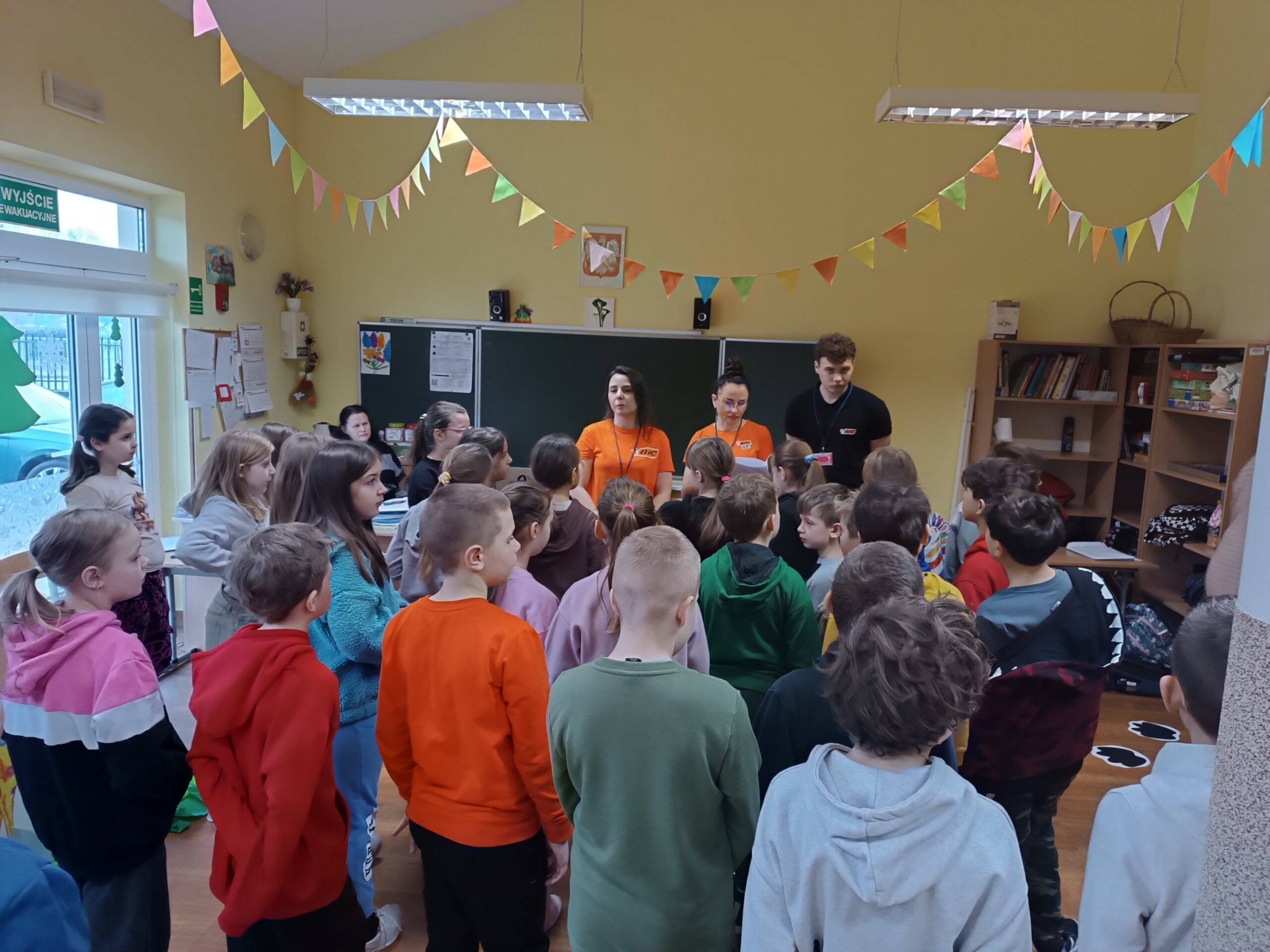 Na zdjęciu widać wolontariuszy z BIC opowiadającym uczniom o tym czego będą dotyczyły zajęcia