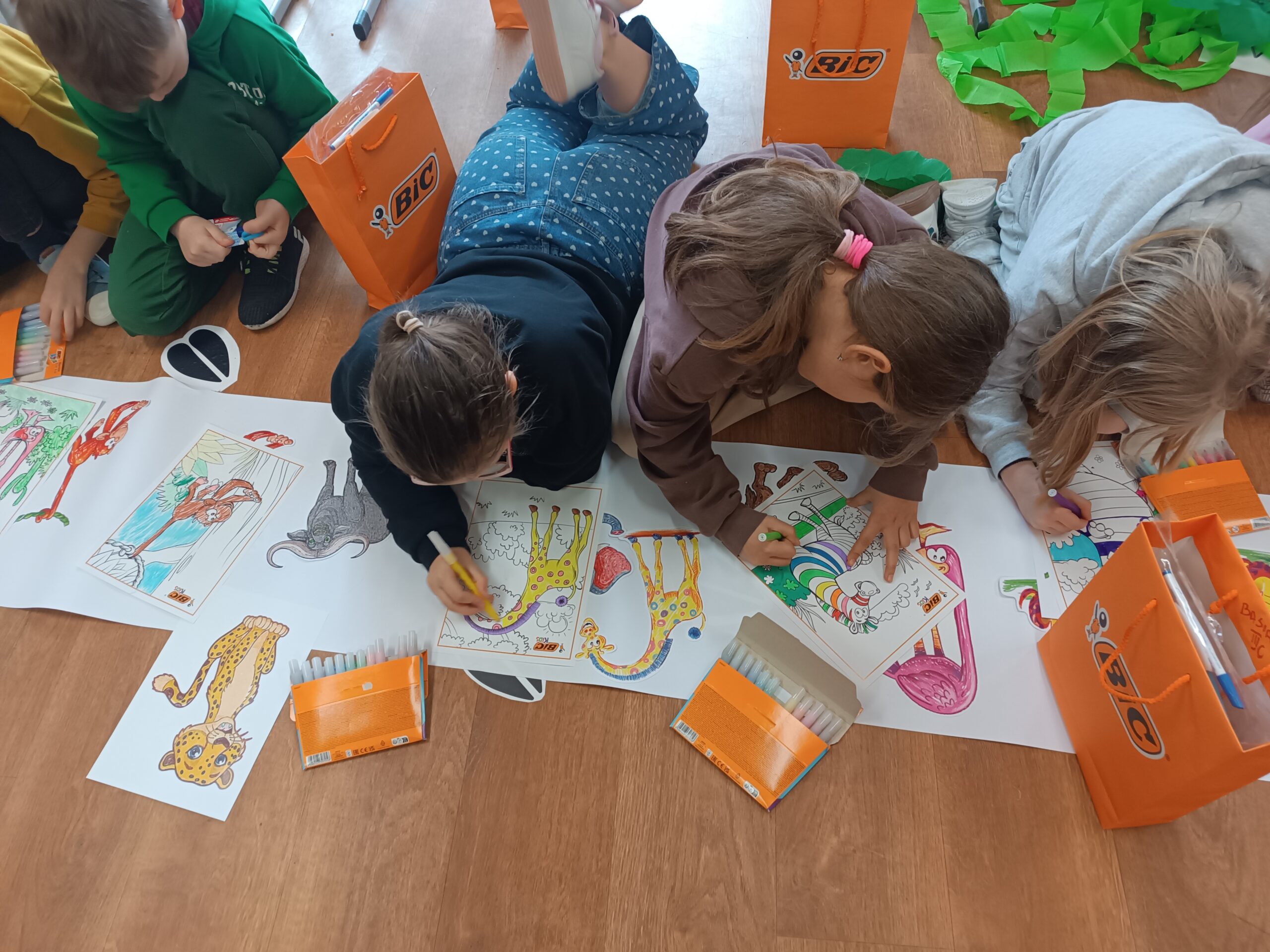 Na zdjęciu widać dzieci kolorujące afrykańskie zwierzęta mazakami i kredkami z firmy BIC