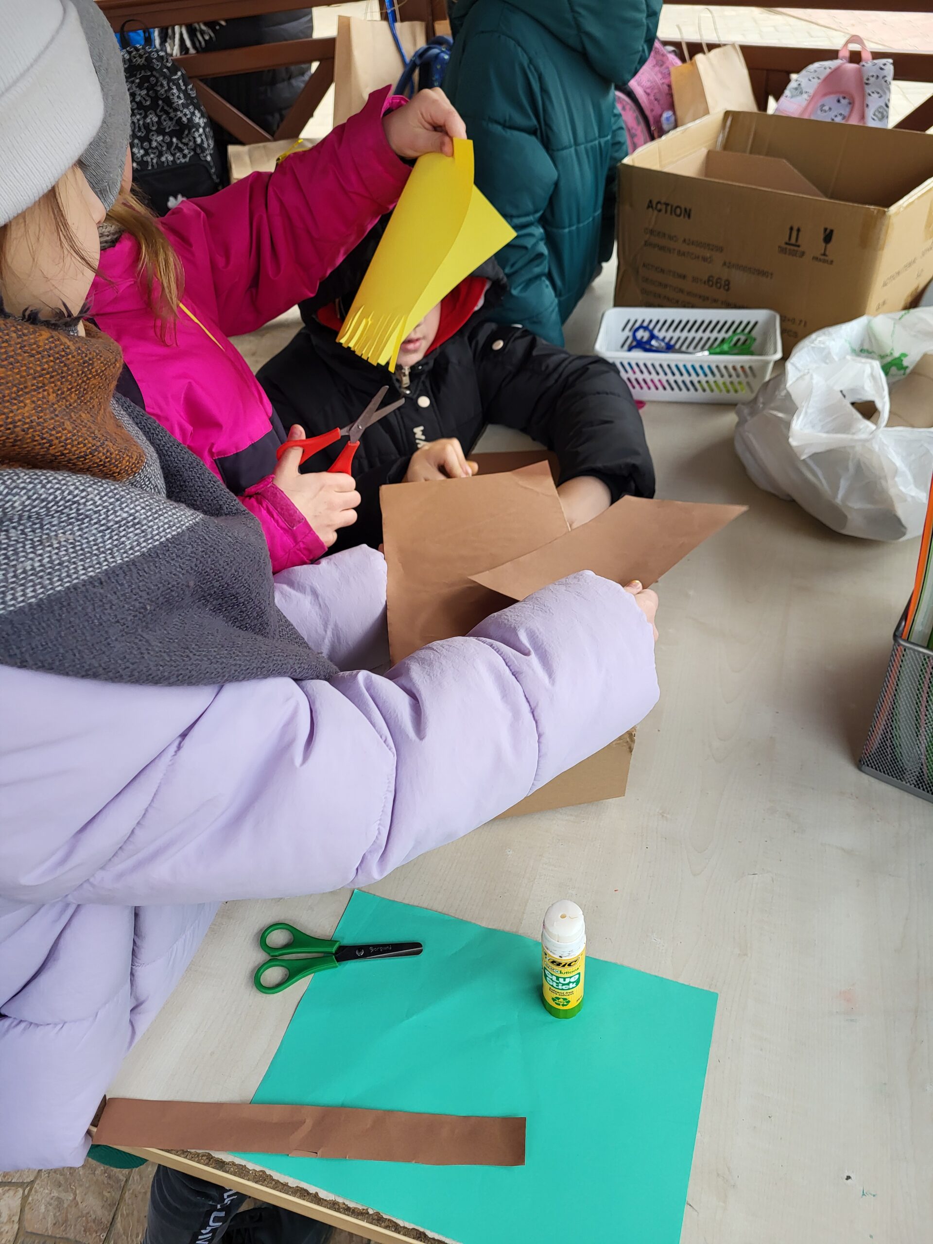 Na zdjęciu widać jak dzieci wykonują ozdoby z rolek i papieru do szopki bożonarodzeniowej