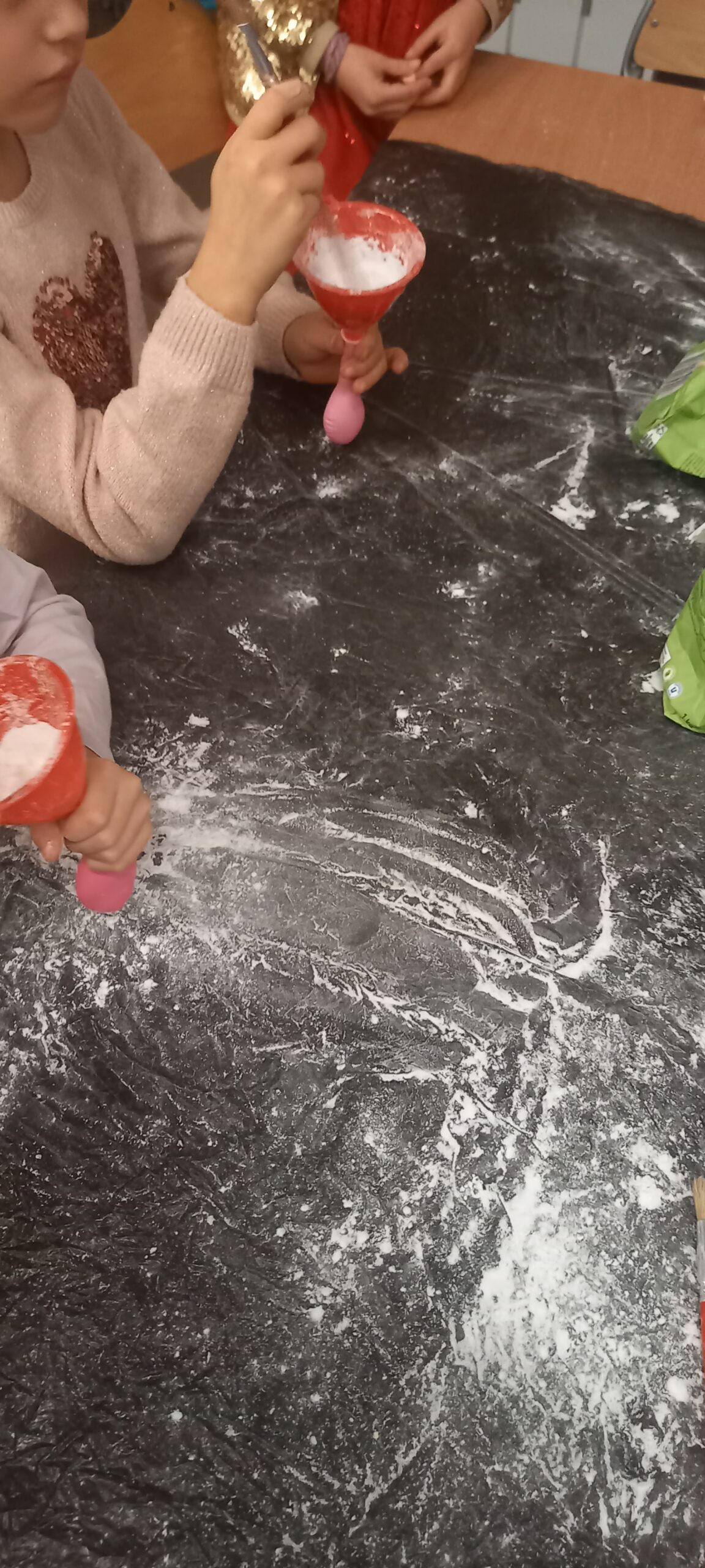 dzieci wykonują gniotki z balonów, wsypują do nich mąkę