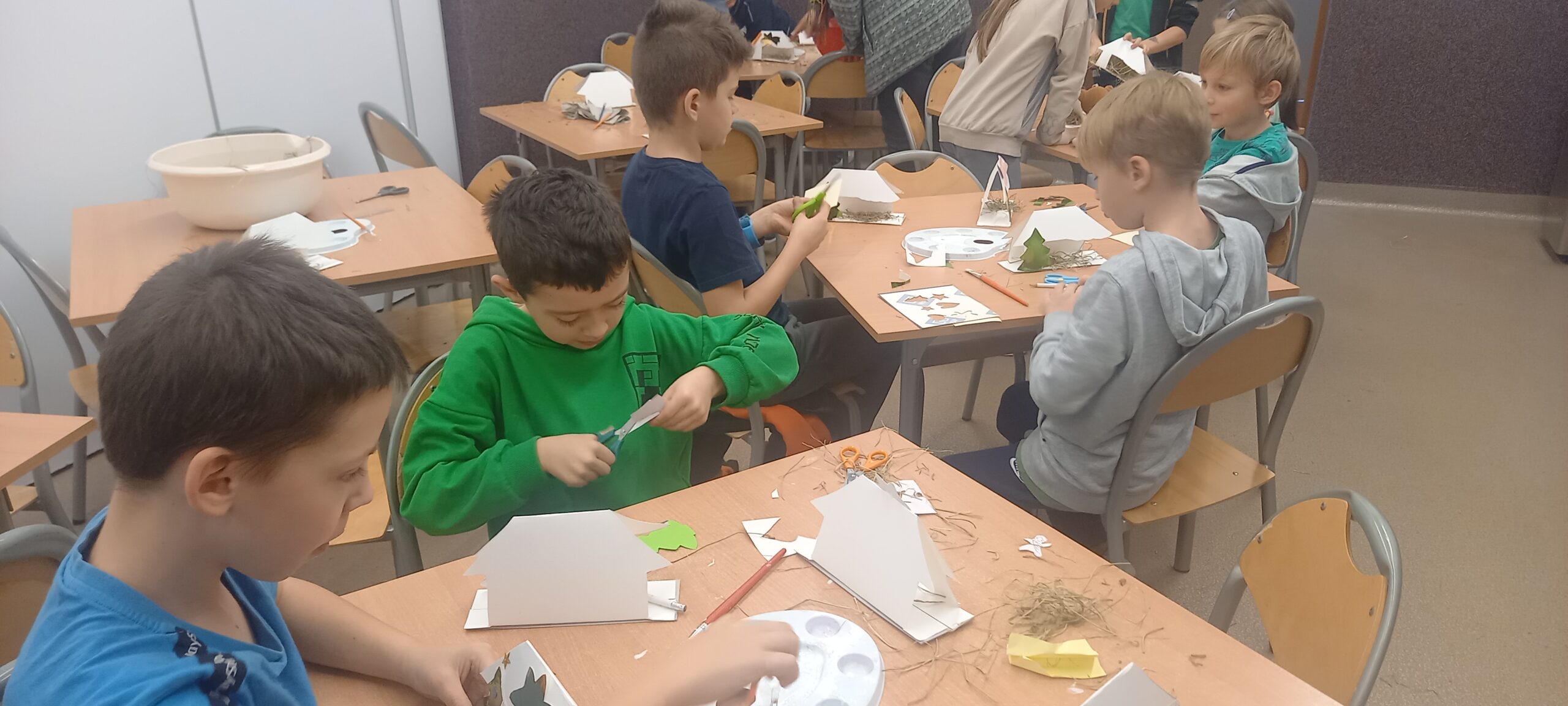 Dzieci wykonują szopki betlejemskie z kartonu i różnych materiałów