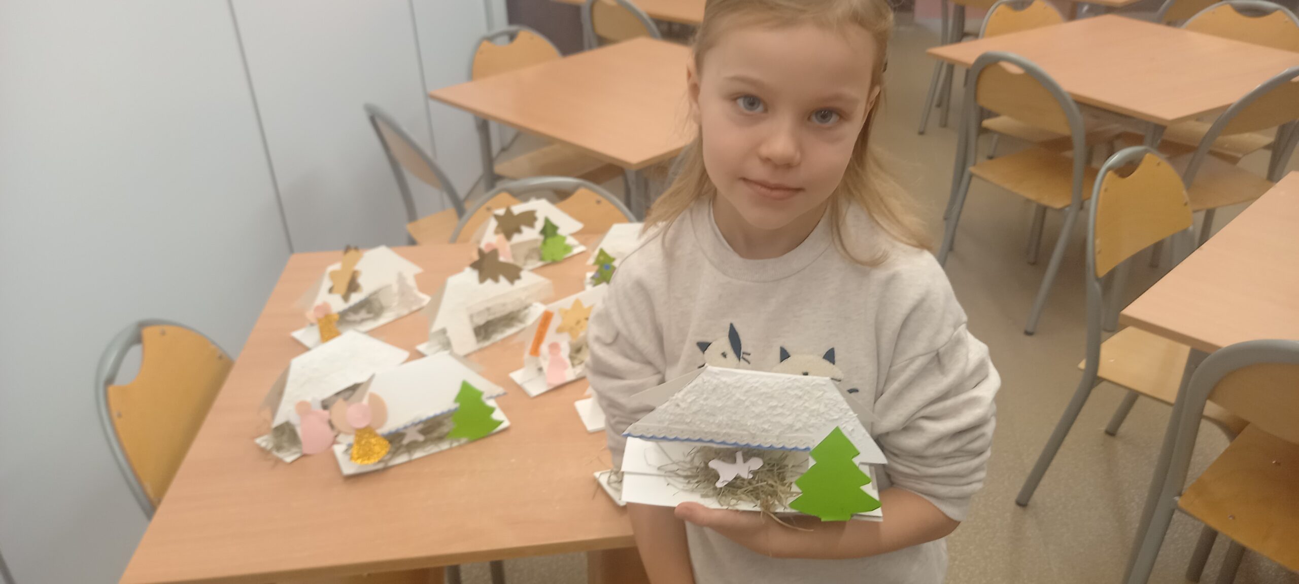 dziewczynka prezentuje wykonaną przez siebie szopkę