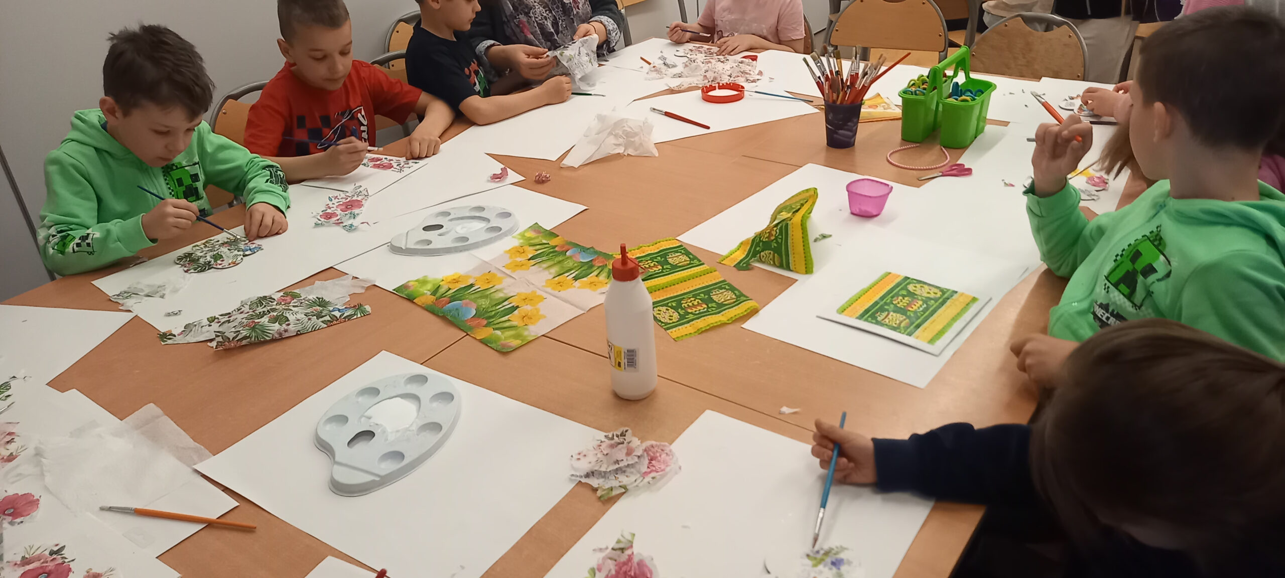 dzieci wykonują obrazki techniką decoupage
