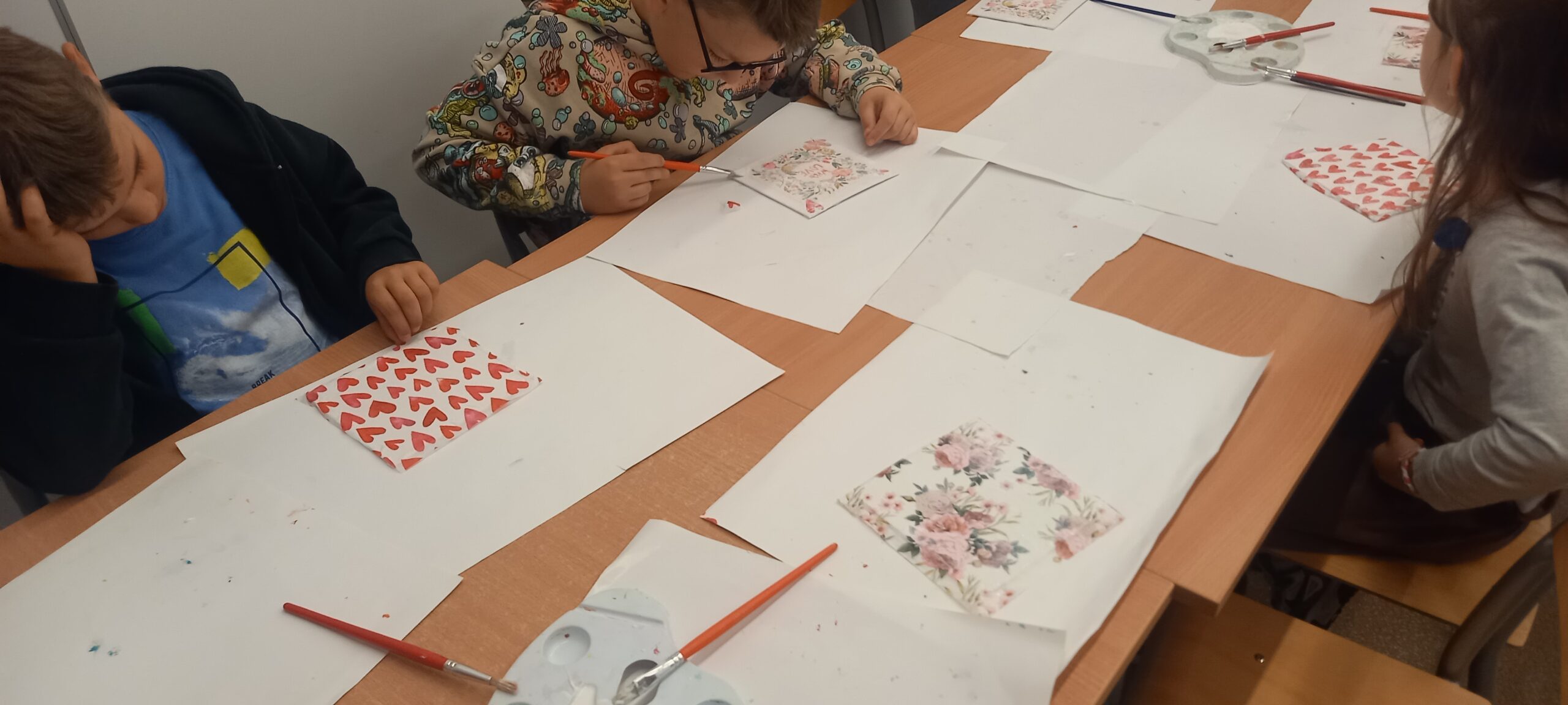 dzieci wykonują obrazki techniką decoupage