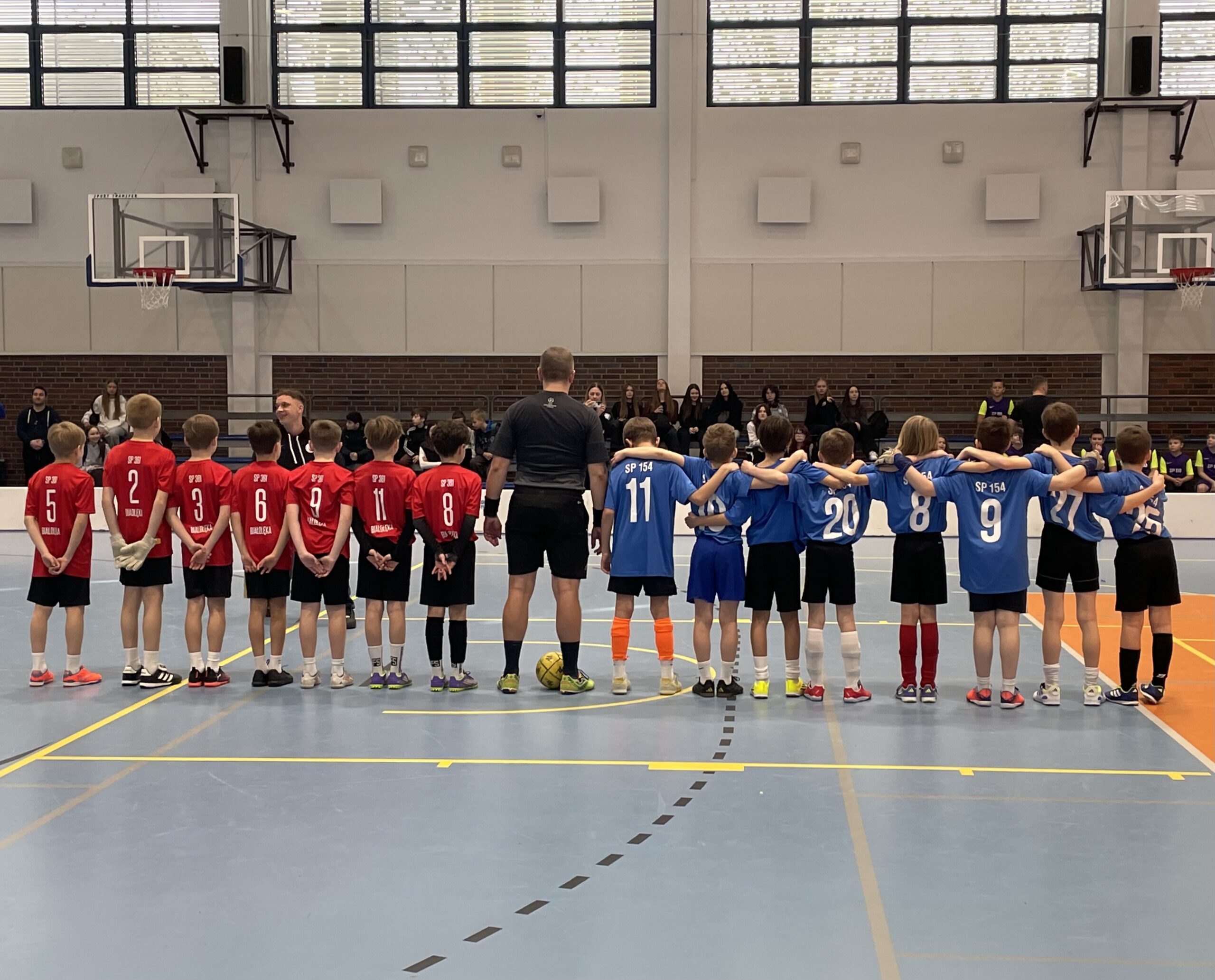 Dwie drużyny stoją razem z sędzią przed meczem finałowym